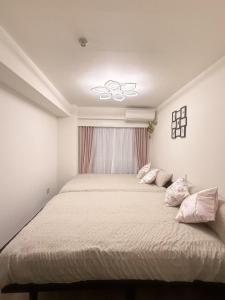 um quarto com uma cama grande e almofadas cor-de-rosa em Shinjuku Kabukicho 新宿最中心 東新宿5分 新宿9分 MAX4人 直達 渋谷原宿上野秋葉原 em Tóquio