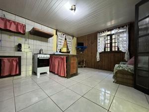 a room with a kitchen with a stove top oven at Pousada do Oasis in Morretes