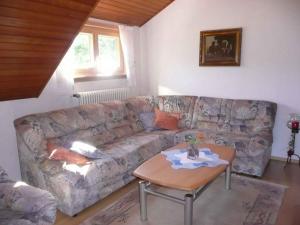 ein Wohnzimmer mit einem Sofa und einem Tisch in der Unterkunft Apartment Herbert Panter in Bad Peterstal-Griesbach
