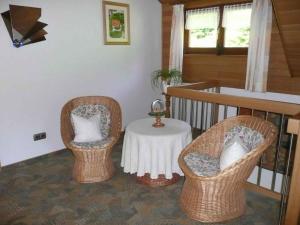 2 Korbstühle und ein Tisch in einem Zimmer in der Unterkunft Apartment Herbert Panter in Bad Peterstal-Griesbach