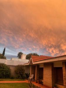 une maison avec un ciel nuageux en arrière-plan dans l'établissement Departamento Temporal, à San Fernando del Valle de Catamarca