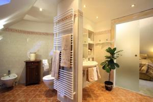 a bathroom with a sink and a toilet and a bed at Romantic Cottage in Pitten