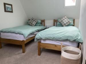 two beds sitting next to each other in a bedroom at 2 smw in Peebles