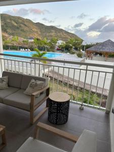 a balcony with a couch and a view of a pool at Easy Friendly SXM in Cul de Sac