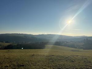a field with the sun shining on the horizon at Ferienhaus MaLu in Nonnweiler