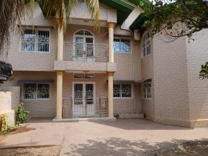 ein großes Backsteinhaus mit Säulen und Fenstern in der Unterkunft Appartement Villa Saran, Nongo in Conakry