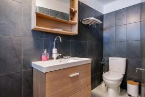 a bathroom with a white sink and a toilet at Octopus Garden, Poros-Kefalonia in Póros Kefalonias