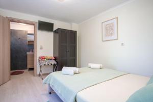 a white bedroom with a bed and a bathroom at Octopus Garden, Poros-Kefalonia in Póros Kefalonias