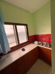 a small kitchen with a sink and a window at Majki Beach Apartments in Sarandë +147 photos