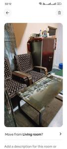 a living room with two chairs and a table at Lokbhgwat house in Jhūsi