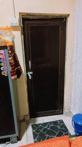 a black door with a mat in front of it at Lokbhgwat house in Jhūsi