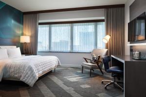 a hotel room with a bed and a desk and a chair at Le Meridien Houston Downtown in Houston +47 photos
