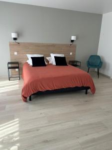 ein Schlafzimmer mit einem großen Bett und einer roten Decke in der Unterkunft L'Obsidienne in Virecourt