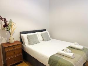 a bedroom with a bed and a dresser with towels on it at Cosy Flat at Temple Bar Dublin in Dublin