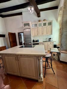 a kitchen with a large island in the middle of it at Maison du Roy / Royal Chambers in Saint-Antonin +86 photos