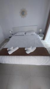 巴亚马雷Cora Apartment的一张白色的大床，上面有两条白毛巾