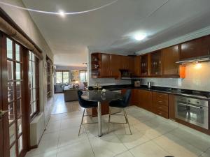 a kitchen with wooden cabinets and a table with chairs at The Little Mongrel Deluxe Space Bryanston in Johannesburg