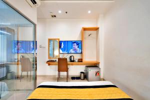 une chambre avec un lit, un bureau et une télévision dans l'établissement S79 Residences Son Mi 839 Le Hong Phong Street, à Hô-Chi-Minh-Ville