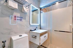 une salle de bain blanche avec un lavabo et une douche dans l'établissement S79 Residences Son Mi 839 Le Hong Phong Street, à Hô-Chi-Minh-Ville
