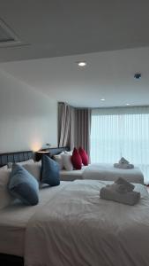 a hotel room with two beds with pillows on them at Kashouse hatyai in Ban Khlong Pleo