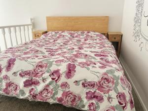 1 cama en un dormitorio con colcha de flores en Living Oasis, en Auckland