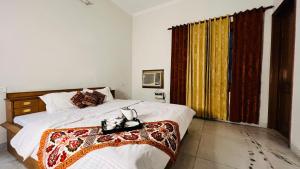 a bedroom with a bed and a large window at The Lawn House : 3BHK Furnished Villa with Lawn in Amritsar