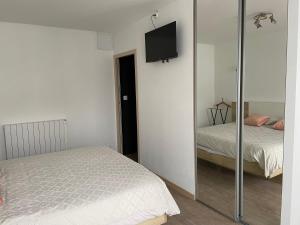 a bedroom with a bed and a tv on a wall at Meublé 42 m2 à Vittel proche Thermes-SPA in Vittel