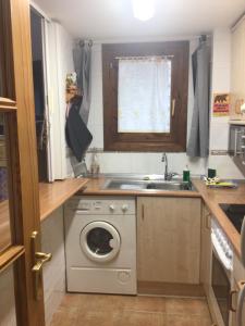 a kitchen with a washing machine and a sink at Paso del Onso in Escarrilla +69 photos
