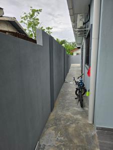 a motorcycle parked next to a wall next to a building at Kak Nah Homestay A Mus'lim Only in Taiping