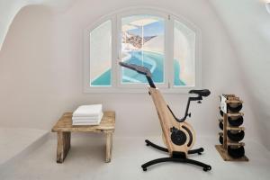 pokój z rowerem treningowym obok okna w obiekcie Mystique, a Luxury Collection Hotel, Santorini w mieście Oia