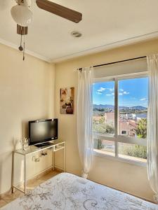 Una sala de estar con televisión y una gran ventana. en Cala AZUL Gran Terraza con BBQ, en Cabo de Palos 35 fotos más