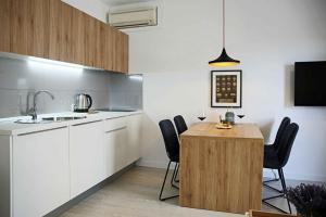 a kitchen with a wooden table and black chairs at Apartments Božena in Vodice