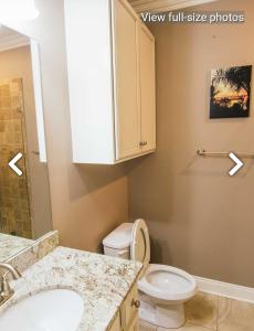a bathroom with a white toilet and a sink at Sea la vie in Grand Isle