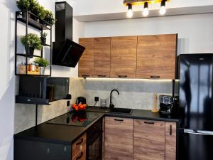 a kitchen with wooden cabinets and a black refrigerator at Osiedlowa 7 in Tylicz