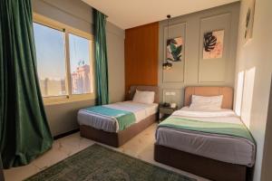 a small room with two beds and a window at Museum Plaza in Cairo +177 photos