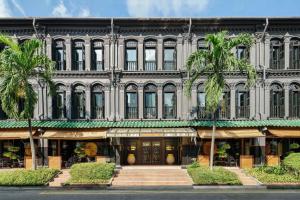 a large building with palm trees in front of it at Duxton Reserve Singapore, Autograph Collection in Singapore