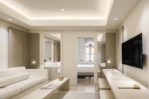 a living room with a white couch and a tv at Duxton Reserve Singapore, Autograph Collection in Singapore +49 photos