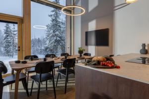 a conference room with tables and chairs and a large window at Joikun Lumo by Hi Ylläs in Äkäslompolo