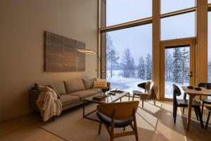 a living room with a couch and a table at Joikun Lumo by Hi Ylläs in Äkäslompolo