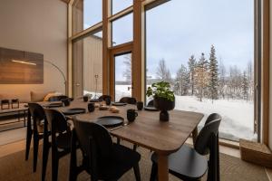 a dining room with a table and a large window at Joikun Lumo by Hi Ylläs in Äkäslompolo +33 photos