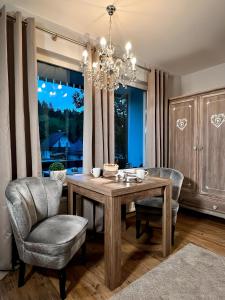 Un comedor con una mesa y sillas y una lámpara de araña. en The Lodge Braunlage, en Braunlage