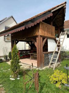 a house with a porch with a bench in the yard at Pensiunea Casa Cezara in Silvaşu de Jos