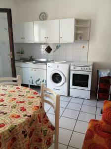 a kitchen with a washing machine and a table at Doria 18 in Lampedusa