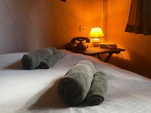 łóżko z ręcznikami położonymi na nim w obiekcie Pinecone Lodge, Eptalofos River Garden Chalet w mieście Eptalofos