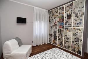 a living room with a white couch and a newspaper wall at L'Agrifoglio Affittacamere in Gattinara