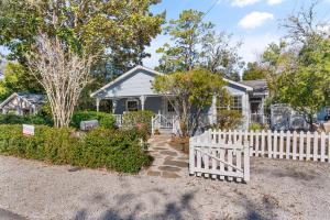 a white fence in front of a house at Sunshine Daydreams - 4310 Seventh Street in Saint Simons Island