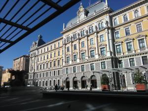 un gran edificio con una estatua delante de él en Hotel Colombia, en Trieste