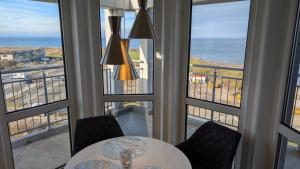 a table and chairs in a room with windows at Turm-Penthouse Heiligenhafen in Heiligenhafen
