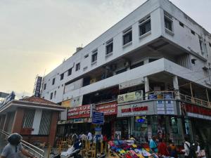 Um edifício alto e branco com pessoas à frente. em Al Noor Residency Business Class Hotel em Chennai