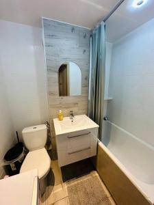 a bathroom with a toilet and a sink and a tub at Wola Ratusz Rooms in Warsaw